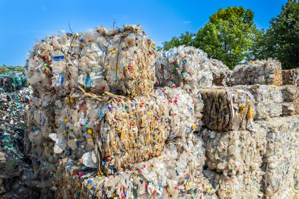 Plusieurs cubes de déchets plastiques compressés dans un centre de traitement des déchets, pour montrer l'importance de l'utilisation d'une caisse à compaction pour réduire le volume des déchets industriels banals (DIB) et respecter la législation en terme de gestion des déchets en entreprise et participer activement aux enjeux écologiques actuels